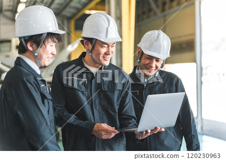 Workers working at a logistics center/distribution center having a meeting on a laptop 120230963
