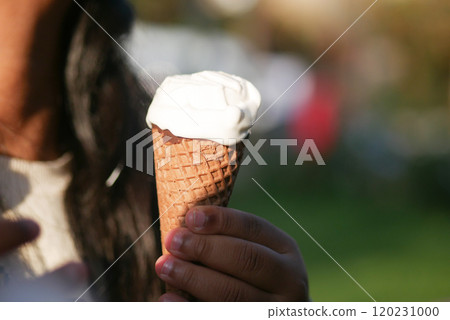 A delicious ice cream cone held in hand, perfect for enjoying on a sunny summer day 120231000