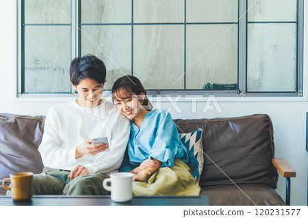 一對年輕夫婦一起看智能手機 120231577
