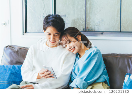 一對年輕夫婦一起看智能手機 120231580