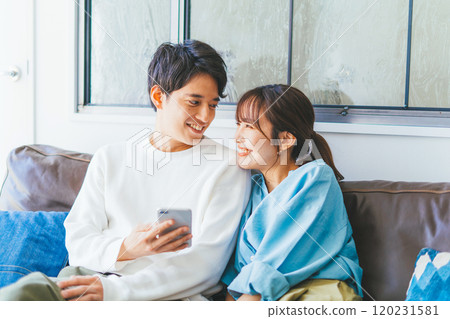A young couple looking at a smartphone together 120231581