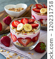 Delicious yogurt parfait with fresh strawberries and bananas, topped with granola. 120231758