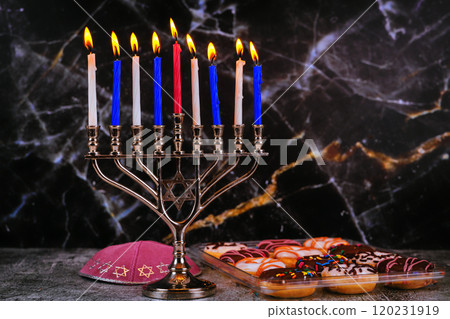 As symbol of Jewish holiday Hanukkah, menorah contains nine lit candles donuts kippah rests on table 120231919