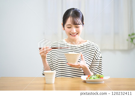 年輕女子吃米飯 120232411