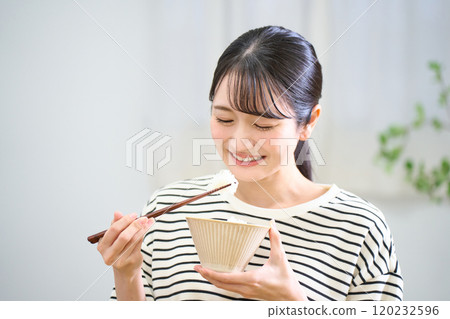 年輕女子吃米飯 120232596