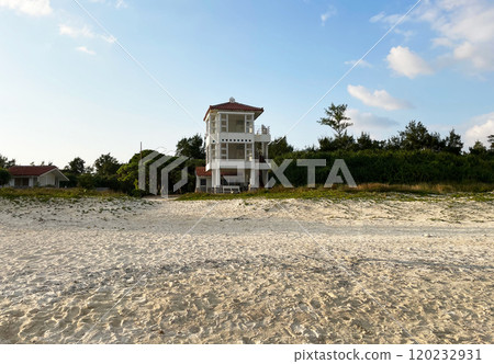 A view of a white watchtower and a sandy beach on the seaside A view of a white watchtower and a sandy beach on the seaside 120232931