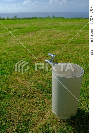 Seaside meadow and water tap 120232973