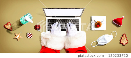 Santa Claus using a laptop computer with a mask and a sanitizer bottle 120233720