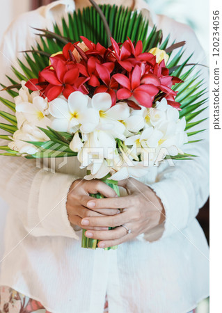 Woman hand wearing a diamond ring and holding flower bouquet. Idea for marriage proposal, romantic surprise, wedding, engagement and valentines day concept 120234056