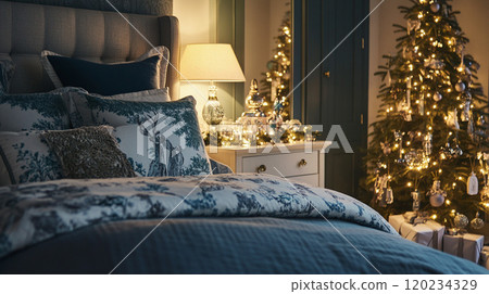 Bed and pillows in bedroom with Christmas tree and holiday decorations 120234329