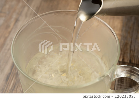 Ginger tea: Pour hot water into a cup containing grated ginger Ginger tea: Pour hot water into a cup containing grated ginger 120235055