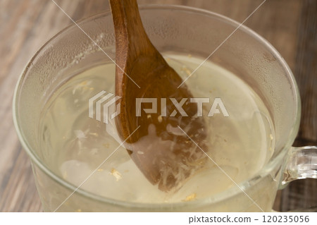 薑湯：將熱水倒入裝有磨碎薑的杯子中。 120235056