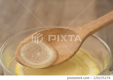 薑湯:用湯匙舀起薑湯。 薑湯:用湯匙舀起薑湯。 120235278