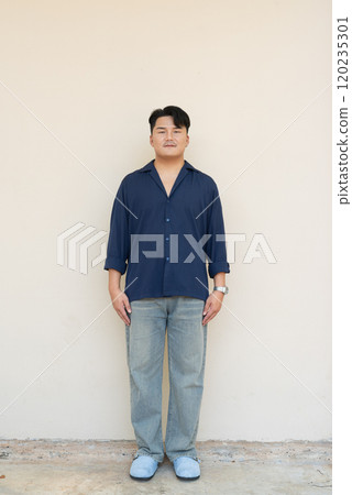 Portrait of Handsome Young Asian Man Against Plain Background 120235301