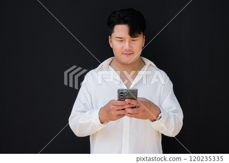 Portrait of Handsome Young Asian Man Against Black Background 120235335