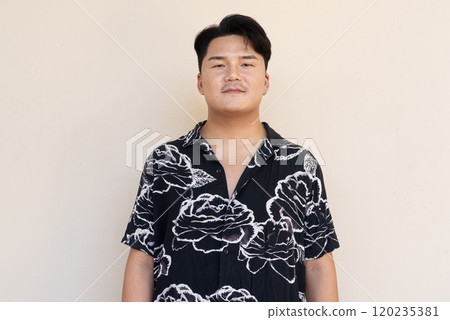 Portrait of Handsome Young Asian Man Against Plain Background 120235381