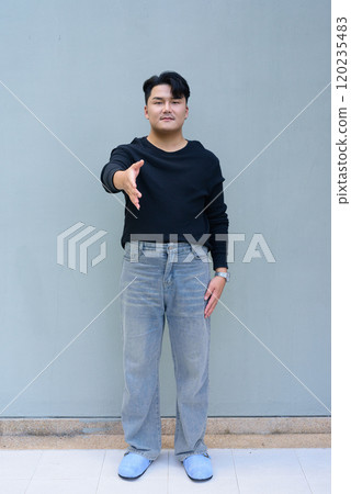 Full Length Portrait of Handsome Young Asian Man Against Plain Background Outdoors 120235483