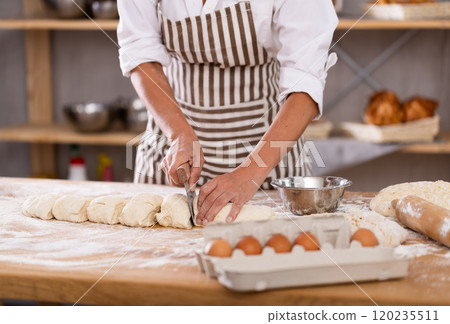 Baker cutting dough with scraper close-up Baker cutting dough with scraper close-up 120235511