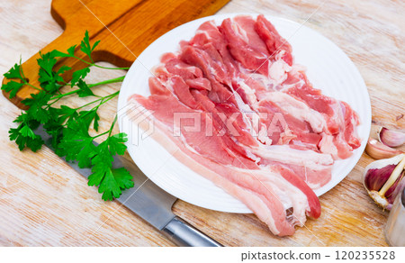 Fresh pork bacon with garlic, pepper on wooden table in kitchen 120235528