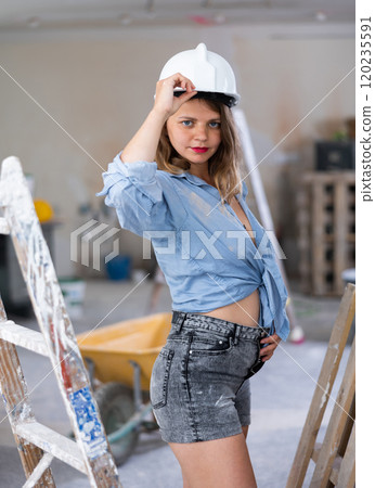 Tempting woman in revealing attire posing in construction site Tempting woman in revealing attire posing in construction site 120235591