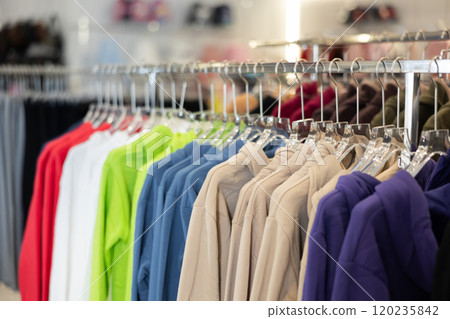 Sweatshirts hung on rack in clothing store 120235842
