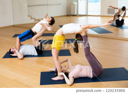 Kids and parents doing stretching exercises during yoga training 120235908
