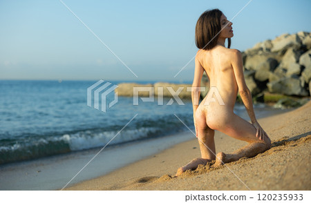 Sexy brunette posing on beach Sexy brunette posing on beach 120235933