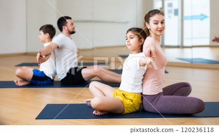 Kids and parents sitting back to back on mats Kids and parents sitting back to back on mats 120236118