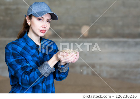 Portrait of woman farmer with a handful of feed calf feed in her hands 120236210