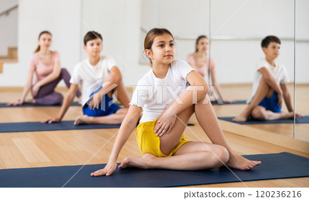 Girl doing lord of the fishes pose in gym Girl doing lord of the fishes pose in gym 120236216