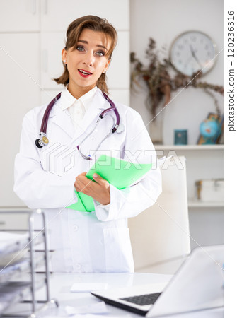 Portrait of positive female doctor with folder Portrait of positive female doctor with folder 120236316