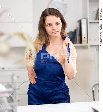Sexy cleaning lady takes off her overalls and poses in modern office 120236359