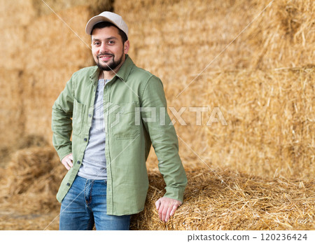 Man posing at straw storage on farm 120236424