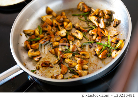 Champignons with asparagus fried in frying pan 120236491