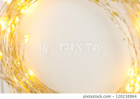 A bright gold-colored Christmas garland lies in a circle on a white background with space for text in the center. The concept of the holiday, Christmas and New Year. High quality photo A bright gold-colored Christmas garland lies in a circle on a white background with space for text in the center. The concept of the holiday, Christmas and New Year. High quality photo 120238864