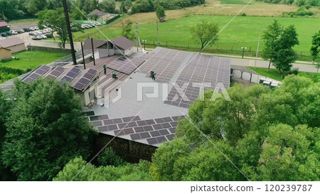 Workers installing solar panels on the roof of a house,which converts solar energy. Workers in special outfit talk about sunny cells installation. Translation: the name of the city of Luzhansky 2. Workers installing solar panels on the roof of a house,which converts solar energy. Workers in special outfit talk about sunny cells installation. Translation: the name of the city of Luzhansky 2. 120239787