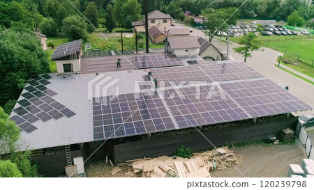 Workers installing PV solar panels on the roof of a house,which converts solar energy into electric energy. Concept of work. Workers in special outfit walk and talk about sunny cells installation. Workers installing PV solar panels on the roof of a house,which converts solar energy into electric energy. Concept of work. Workers in special outfit walk and talk about sunny cells installation. 120239798