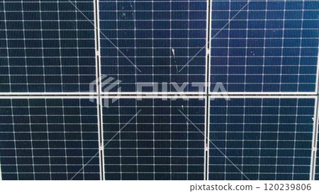 Closeup of surface of blue photovoltaic solar panels mounted on building roof for producing clean ecological electricity. Production of renewable energy concept. Drone Aerial View of solar panels. Closeup of surface of blue photovoltaic solar panels mounted on building roof for producing clean ecological electricity. Production of renewable energy concept. Drone Aerial View of solar panels. 120239806