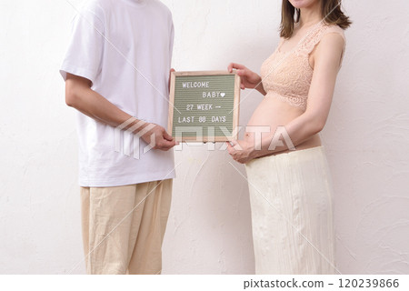 一位丈夫擁抱著一位拿著信板的年輕孕婦 一位丈夫擁抱著一位拿著信板的年輕孕婦 120239866