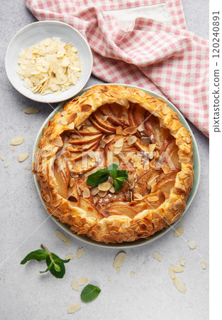 Delicious homemade apple galette with almond flakes and fresh mint on table 120240891