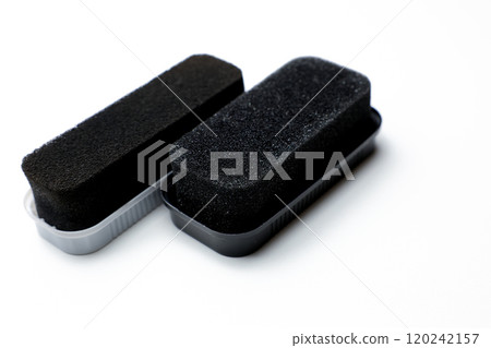 Two black leather shoe cleaning sponges with shoe polish lying close-up on a white background. High quality photo 120242157