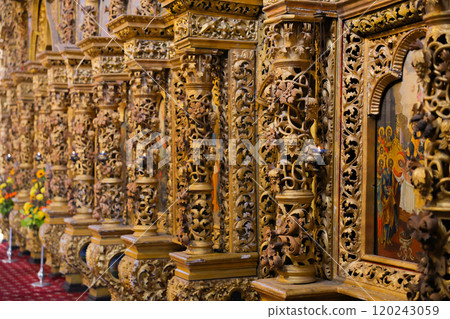 Volumetric columns of golden color with stucco molding of flowers, leaves and twigs, between which the bark of the Orthodox Church is visible. The concept of Faith, Church, Orthodoxy. High quality 120243059