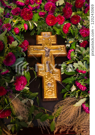 Golden Cross Crucifixion Lying Against Background Pink Flowers Vertical Photo. Concept of Faith, Church. High quality photo 120243069