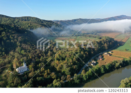 Aerial view of quiet river and forest in a misty morning 120243313