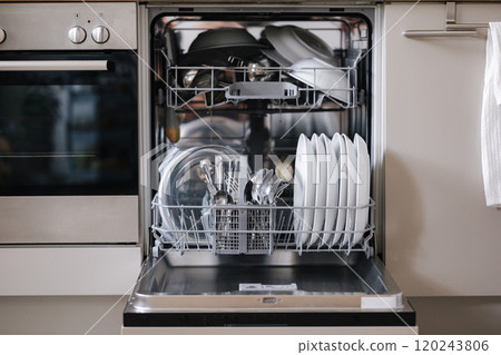 Open dishwasher fully loaded with clean dishes, ready to be emptied 120243806