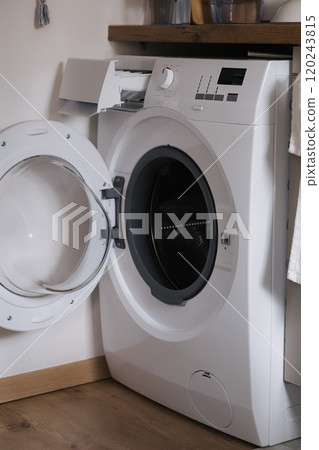 Modern washing machine with the door open, ready for loading or unloading. Modern washing machine with the door open, ready for loading or unloading. 120243815