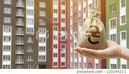 Ukrainian hryvnia bag against the background of modern high-rise buildings. Investing in the purchase of real estate. Affordable housing and mortgage rates. Ukrainian hryvnia bag against the background of modern high-rise buildings. Investing in the purchase of real estate. Affordable housing and mortgage rates. 120244211
