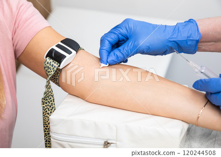 Nurse preparing patients arm for taking blood sample 120244508