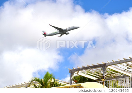 A passenger plane taking off over Umikaji Terrace A passenger plane taking off over Umikaji Terrace 120245465