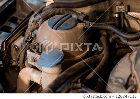 Close-up of a Car's Engine Coolant Reservoir with Surrounding Components Close-up of a Car's Engine Coolant Reservoir with Surrounding Components 120247113
